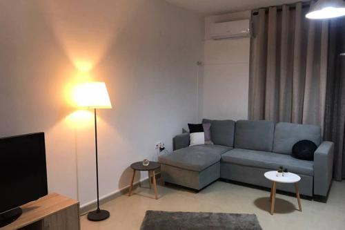 a living room with a blue couch and a television at Beauty Home Orestiada Center in Orestiada