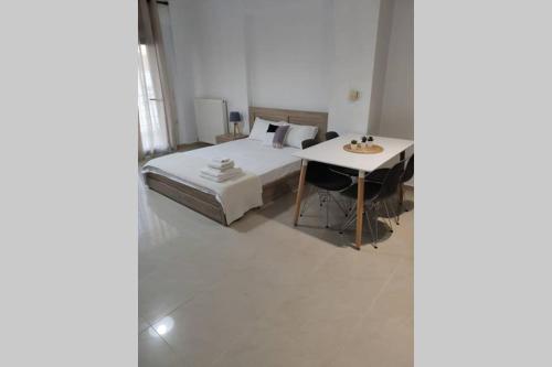 a white bedroom with a bed and a table at Beauty Home Orestiada Center in Orestiada