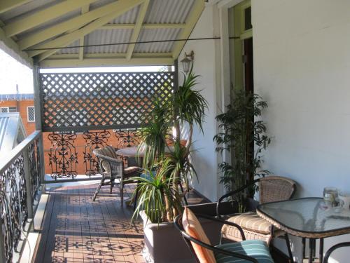 an outdoor patio with tables and chairs and plants at Heritage Guesthouse in South West Rocks