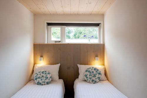 Sint MaartensvlotbrugにあるAan Noordzee Vakantiehuis aan zee 4 Personenの窓付きの小さな部屋のベッド2台