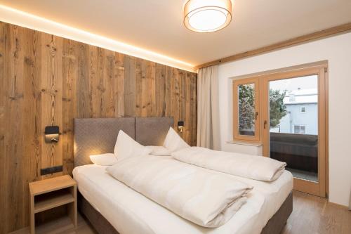 A bed or beds in a room at Angerer Alpine Suiten und Familienappartements Tirol