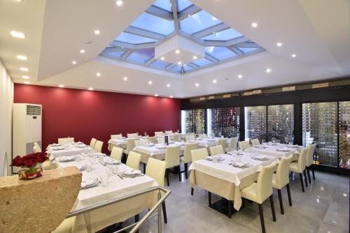 una sala da pranzo con tavoli bianchi e sedie bianche di Caçarola Dois - Alojamento local a Figueira da Foz