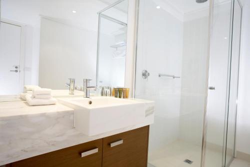 a white bathroom with a sink and a shower at Silverwater Resort Phillip Island in San Remo