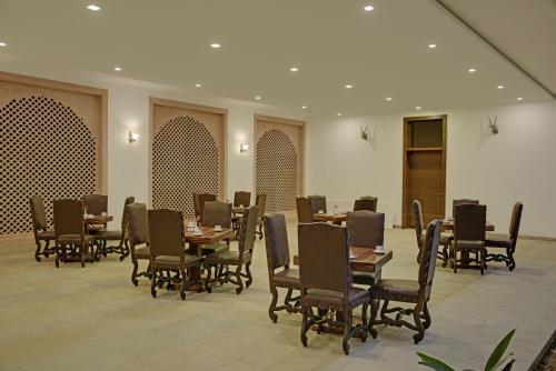 a dining room with wooden tables and chairs at Clarks Safari Ranthambore in Khilchipur