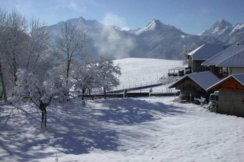 a snow covered field with a train station and mountains at Studio Les Chanterelles in Plan Motmin