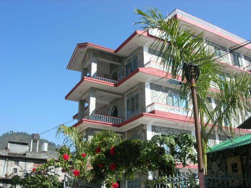 a tall building with a palm tree in front of it at Hotel River Park in Pokhara
