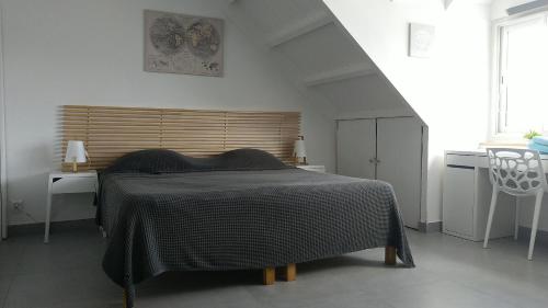 a bedroom with a bed with a black blanket at Friendly Beach House in Baie Nettle