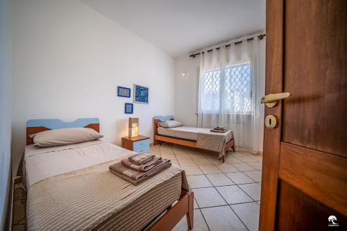 魯法諾的住宿－Manfio's，一间卧室设有两张床和窗户。