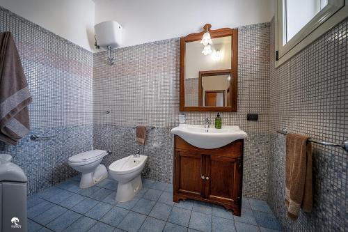 bagno con lavandino, servizi igienici e specchio di Manfio's a Ruffano