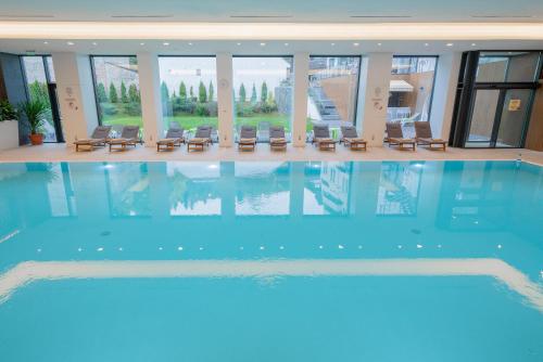 a large swimming pool in a building with chairs in it at Hotel International in Sinaia