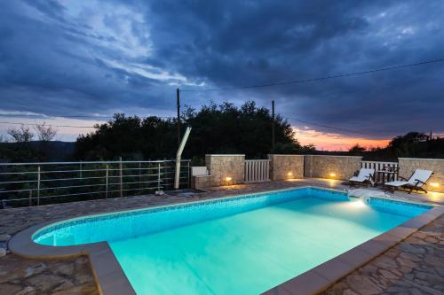 una piscina con puesta de sol en el fondo en Holiday Home Lazuština Paradise, en Mihanići
