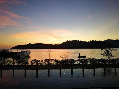 a person in a boat on a lake at sunset at Parama Koh Chang in Ko Chang