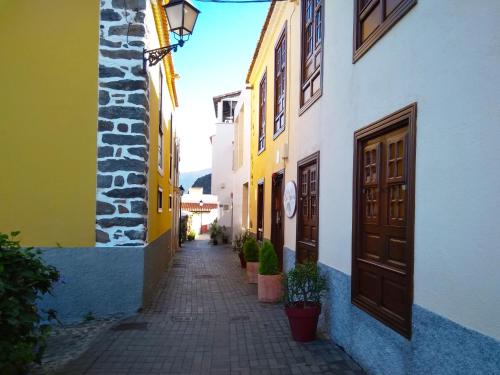 a narrow alley with yellow and white buildings at Casa Rural Los Helechos in Agulo