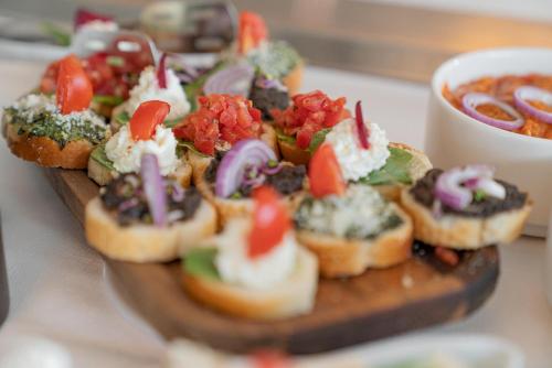 a bunch of small appetizers on a wooden plate at Hotel International in Sinaia