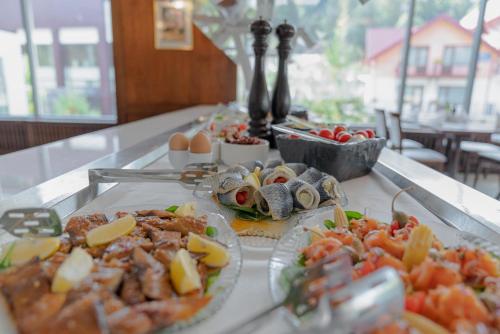 a buffet of food on a table with plates of food at Hotel International in Sinaia