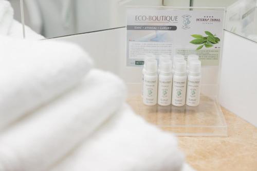 a row of bottles of lotion on a counter at Hotel International in Sinaia