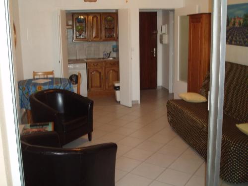 un salon avec un canapé et une chaise dans l'établissement studio 150 m de la mer, à Six-Fours-les-Plages