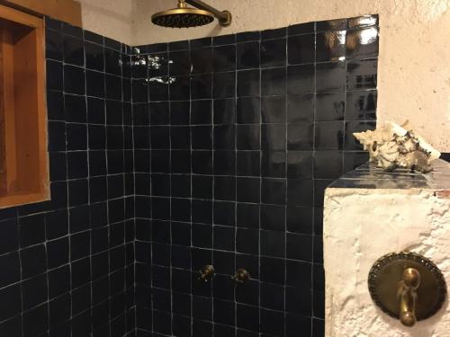 a bathroom with a black tiled wall and a sink at Cabaña del Rio in Huasca de Ocampo