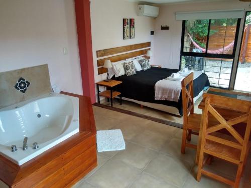 
a hotel room with a bed and a bathtub at Ruca Lemu in Chascomús
