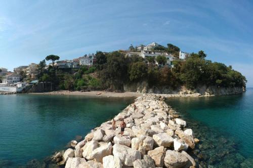 a rocky island in the water with houses on a hill at Historical Center with Garden "The Beach and The Cliff" 4 in Agropoli