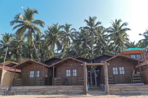 a house on the beach with palm trees in the background at Agonda Paradise in Agonda