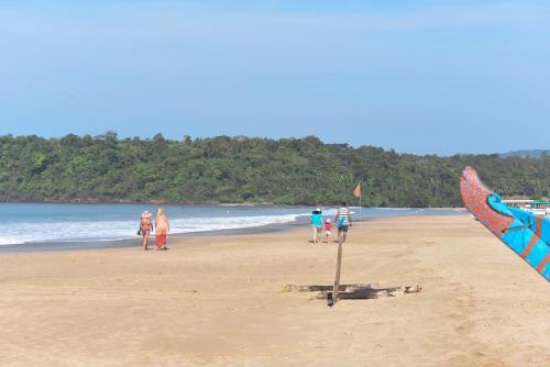 a group of people standing on a beach with a kite at Agonda Paradise in Agonda