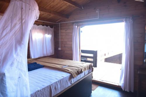 a bedroom with a bed and a large window at Agonda Paradise in Agonda
