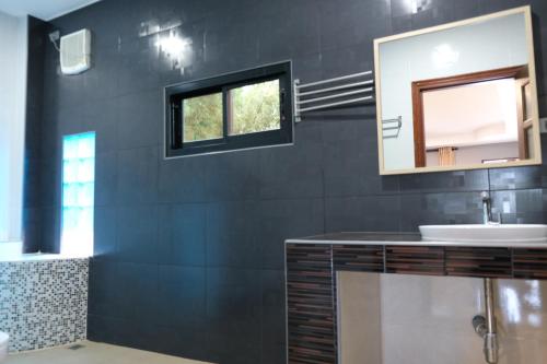 ein Badezimmer mit Waschbecken und Spiegel in der Unterkunft Binlar Home บินหลา โฮม in Nakhon Nayok