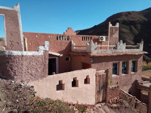 an old building with a mountain in the background at Dar Zara in Ouarzazate