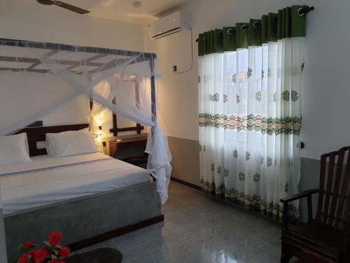 a bedroom with a canopy bed and curtains at Indika's Apartment in Hikkaduwa