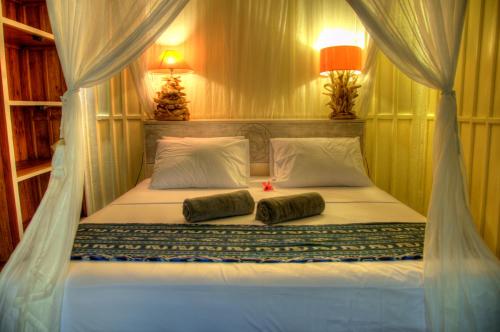 a bed in a room with two pillows on it at Villas SAMALAMA Gili Trawangan in Gili Trawangan