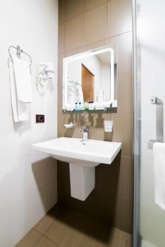 a bathroom with a white sink and a mirror at Elegant Hotel & Resort in Tsaghkadzor