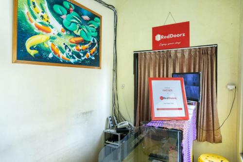 a room with a sign and a picture of a koi at RedDoorz @ Gatot Subroto Ende in Ende