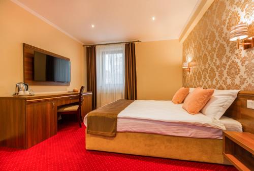 a hotel room with a bed and a desk and a television at BUCUR 9 in Bucharest