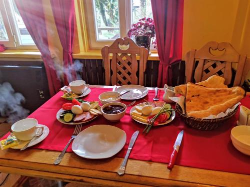 a table with plates of food on a red table cloth at Guest House MARINA in K'obulet'i