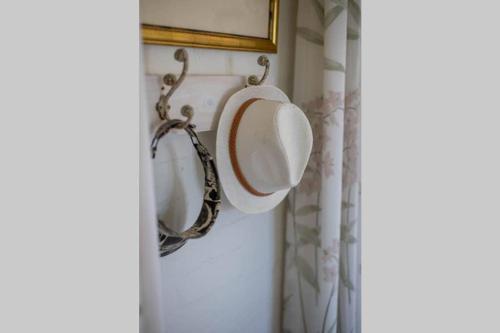 a mirror hanging on a wall in a bathroom at The Amaryllis Luxury Apartment Bella Donna in Bettyʼs Bay