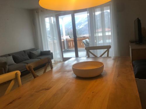 a living room with a wooden table with a bowl on it at Apartment Seeglück am Schliersee - modern, zentral, perfekt für Familien in Schliersee