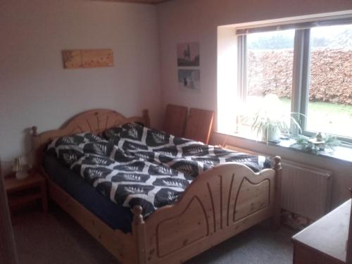 Schlafzimmer mit einem Bett mit einer schwarzen und weißen Bettdecke in der Unterkunft Lindholt in Fjerritslev