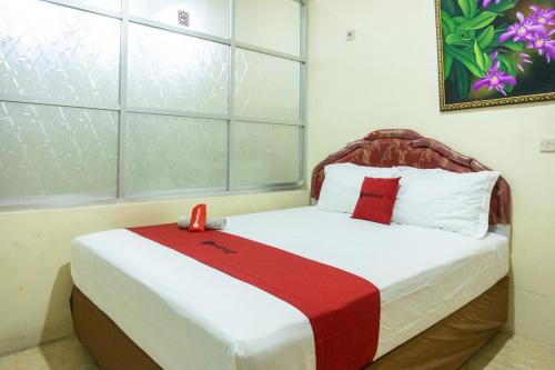 Tempat tidur dalam kamar di RedDoorz near H. Hasan Aroeboesman Airport