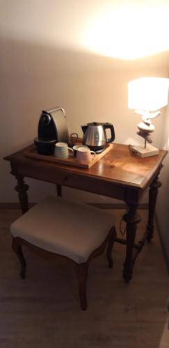a wooden table with a lamp and a telephone on it at La Maison Des Autres, piscine chauffée, chambres d'hôtes proches Uzès, Nîmes, Pont du Gard in Saint-Géniès-de-Malgoirès