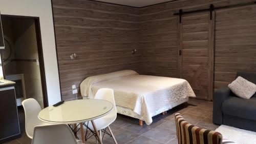 1 dormitorio con 1 cama, 1 mesa y 1 silla en monoambiente cerca del centro en Villa La Angostura