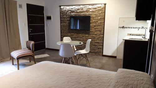 Il comprend une chambre avec une table et des chaises ainsi qu'une cuisine. dans l'établissement monoambiente cerca del centro, à Villa La Angostura