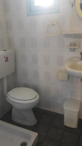 Łazienka z białą toaletą i umywalką w obiekcie DARZENTA ATHINA APARTMENTS Perissa w mieście Perissa