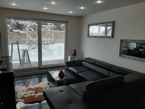 a living room with a black couch and a tv at Villa Košice 2 in Košice