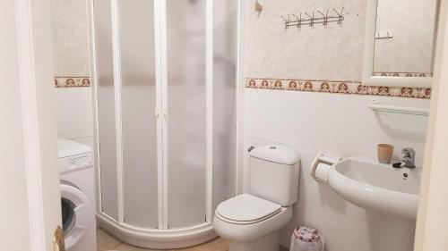 a white bathroom with a toilet and a sink at Marina Palace Paraiso in Playa Paraiso