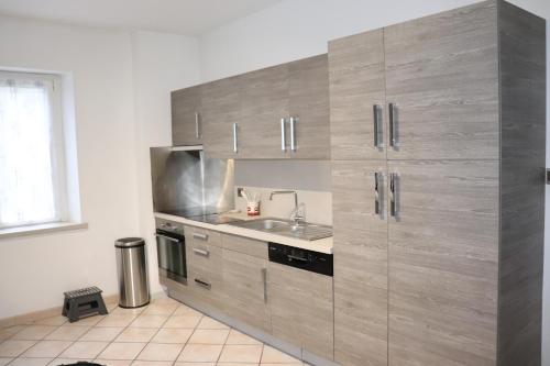 - une cuisine avec une grande armoire en bois et un évier dans l'établissement Villa le Tramway, à Gérardmer