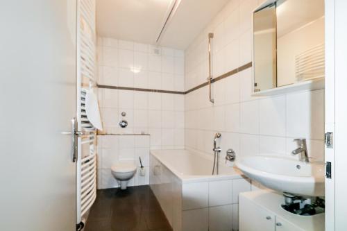 een witte badkamer met een wastafel en een toilet bij Fewo CityLife Köln-Innenstadt in Keulen