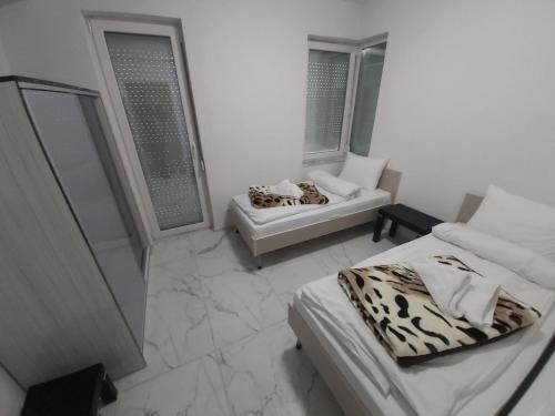 a white room with two beds and a couch at XXL APARTMENTS CiTY CENTAR 1 in Bitola