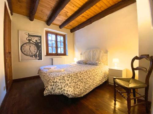 a bedroom with a bed and a clock on the wall at C3 Bordes d'Arinsal, Rustico con Chimenea, Arinsal, Zona Vallnord in Arinsal