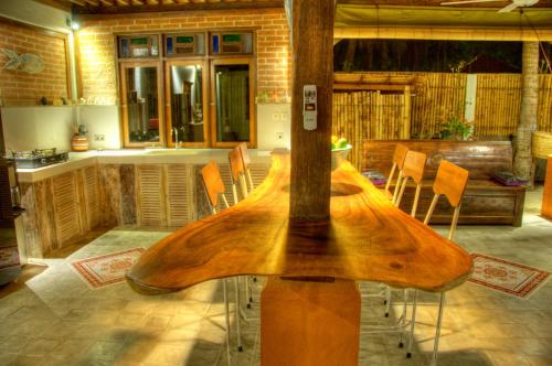 a wooden surfboard on a table in a kitchen at Villas SAMALAMA Gili Trawangan in Gili Trawangan